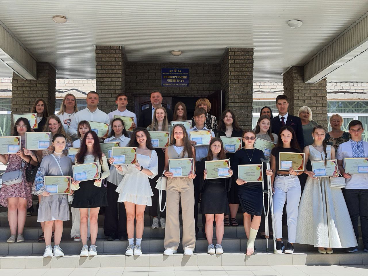 Випускники з свідоцтвами та відзнаками біля гімназії